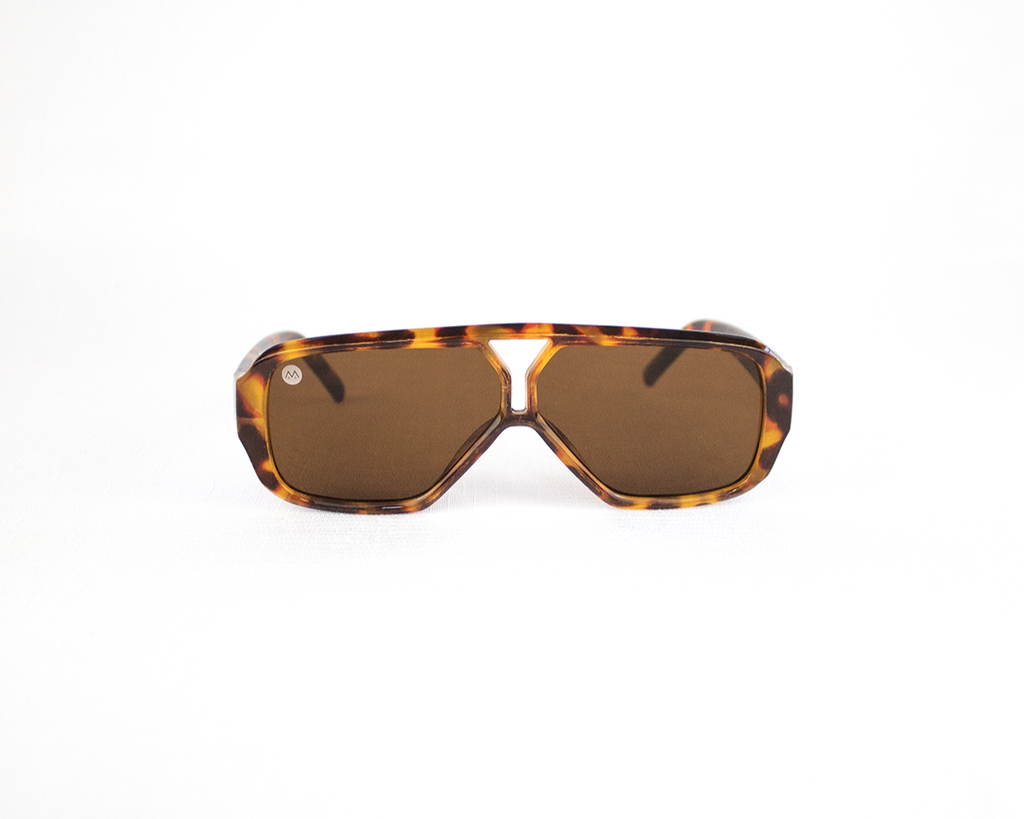 Tortoiseshell sunglasses with brown lenses on a white background