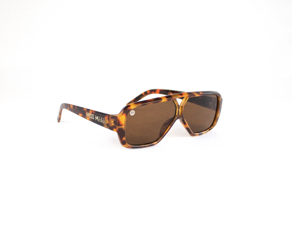Sunglasses with tortoiseshell frame and brown lenses on a white background
