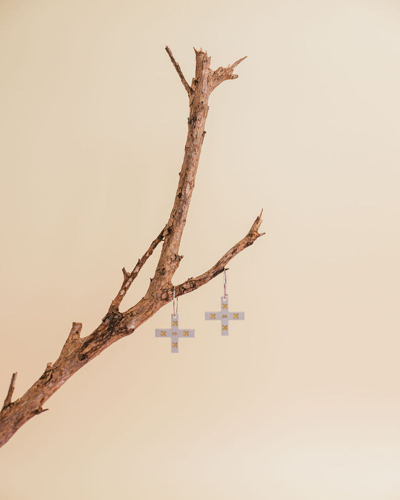 MISS MAIA, May 2022. The Whetū earrings in Grey and Gold are perched on a branch.